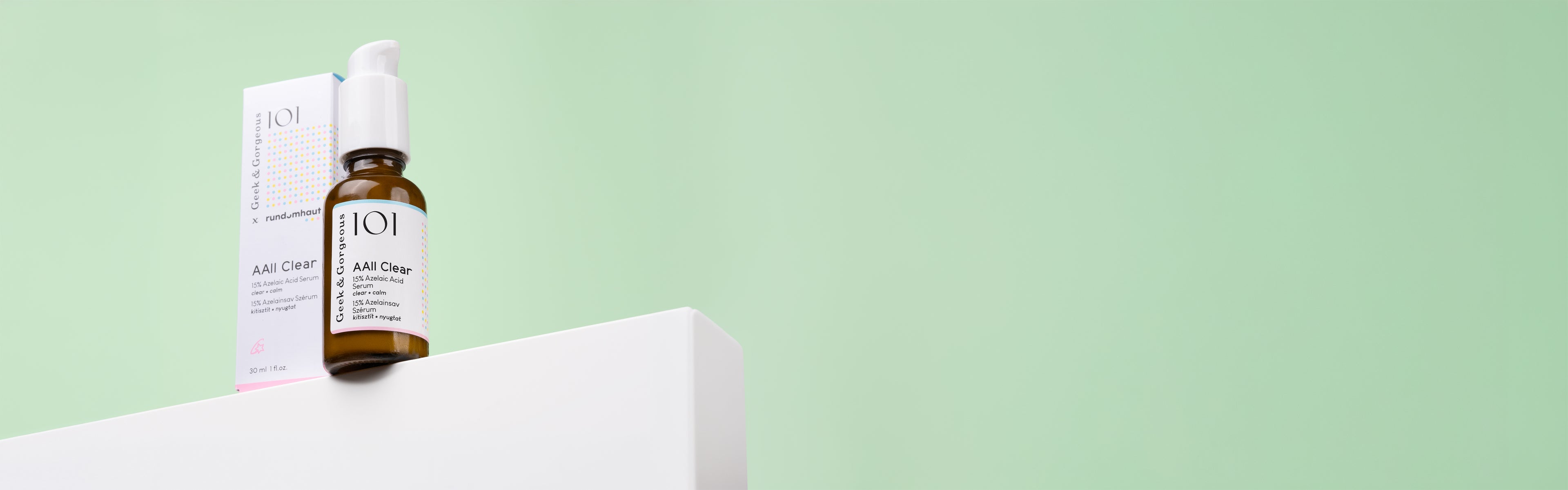 An AAll Clear product box and serum bottle are standing on top of a white podium in front of a mint background. The text says: _hi, 15% Azelaic Acid 💛 -> clearer & calmer skin1621243260e1af0c20-0